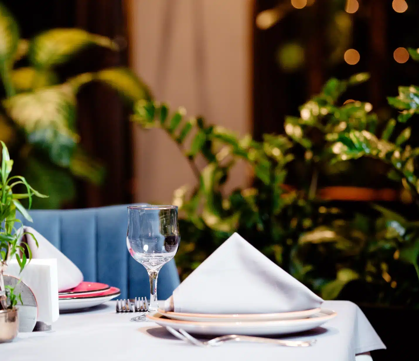 table de terrasse avec différents équipements de restaurant comme ustensiles, assiettes et nappes.